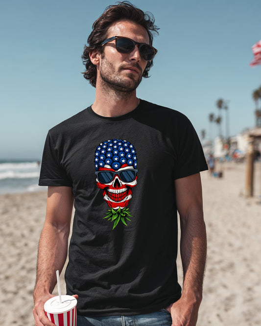 Man wearing a black t-shirt with a red, white, and blue upside-down pineapple skull graphic. Bold patriotic design for edgy summer fashion.