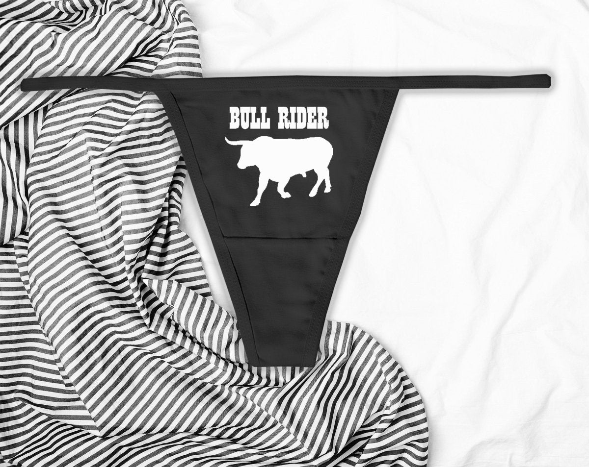 Sexy black thong with “Bull Rider” text in bold white print. Western-inspired lingerie for confident women who love to ride hard and dominate the scene.