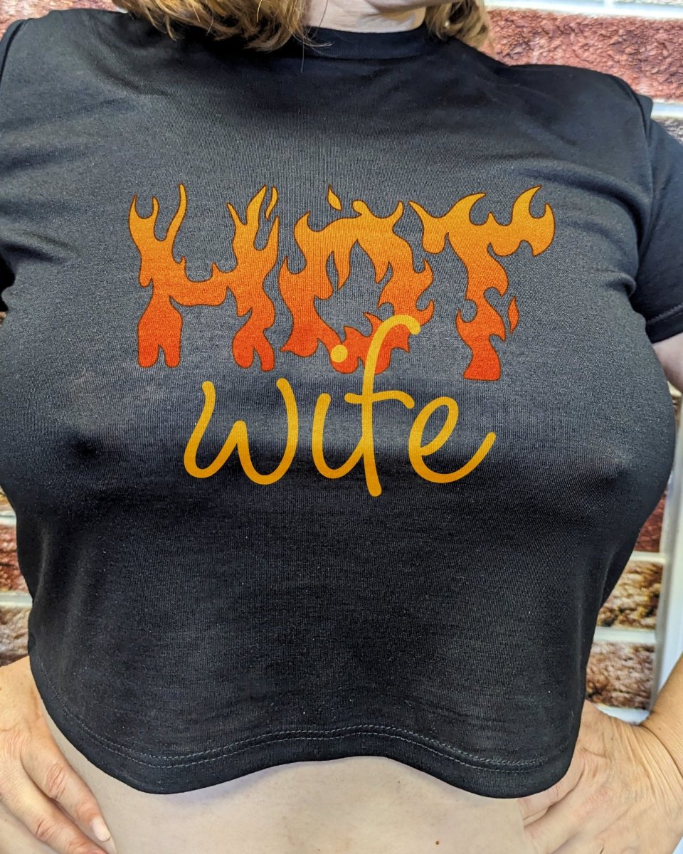 Blonde woman wearing black crop top with flaming “Hot Wife” design – sexy hotwife lifestyle apparel