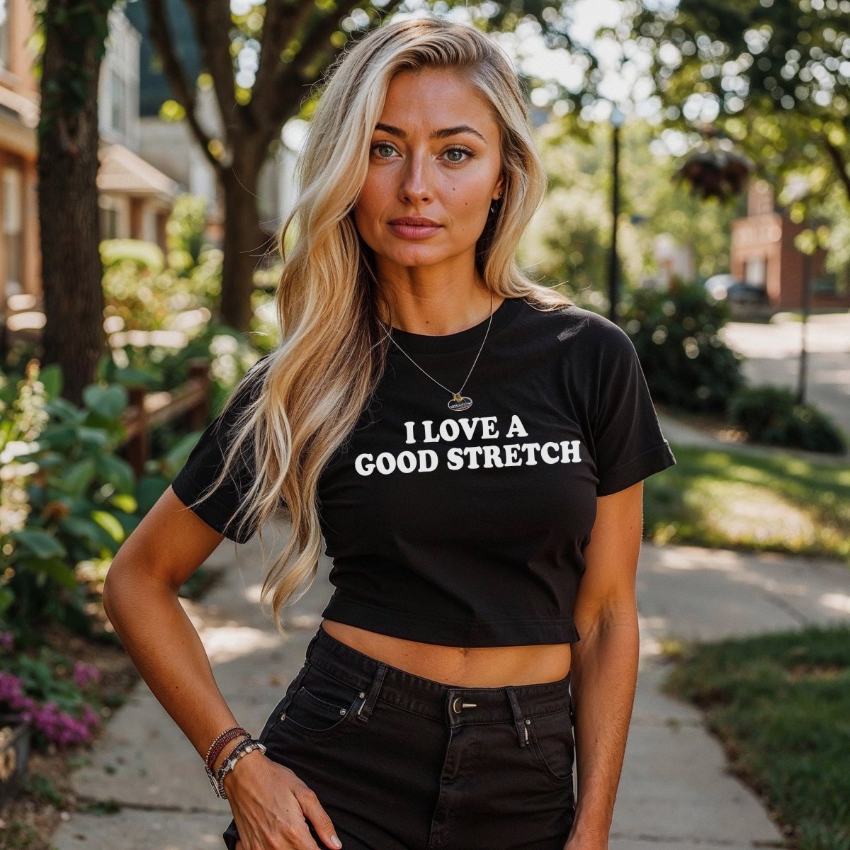 Black short sleeve crop top with “I Love A Good Stretch” printed in bold text across the front. Submissive kink apparel for flexible brats and bondage lovers.