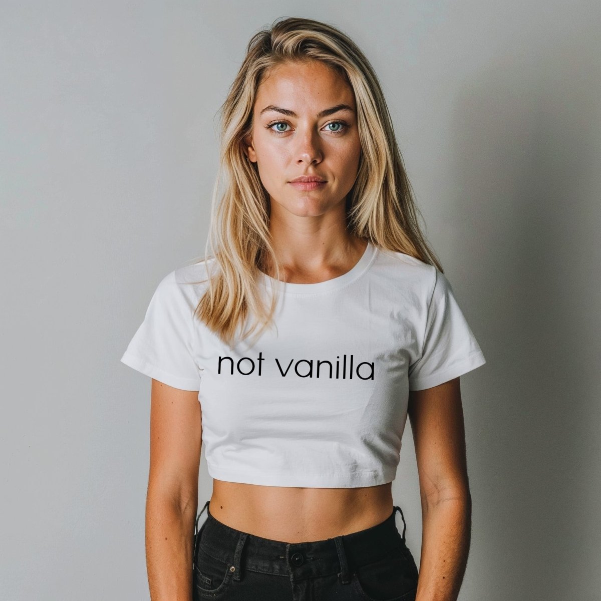 White crop top with “Not Vanilla” printed in bold black text. Kinky lifestyle apparel for brats, subs, and anyone proud to live beyond the basics.