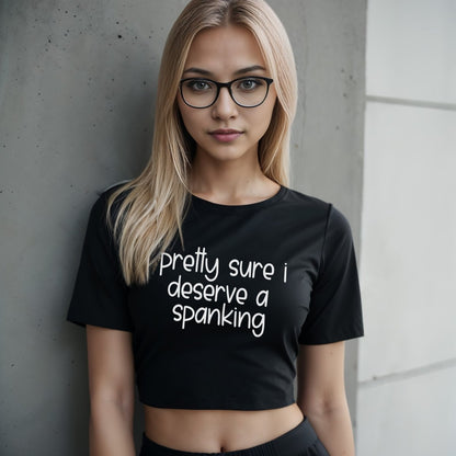 Black crop top with “Pretty Sure I Deserve a Spanking” in bold white text. Bratty kink shirt for submissive play and punishment teasing.