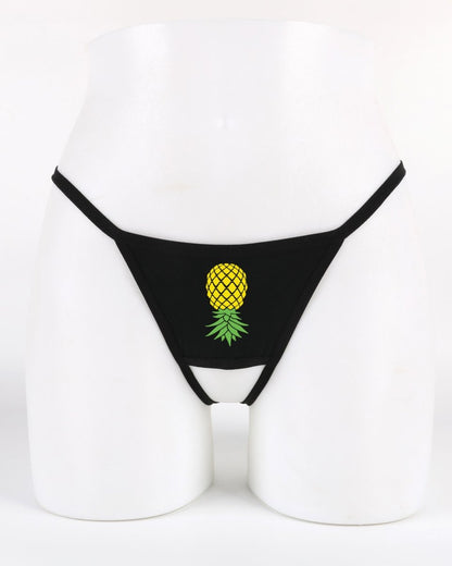 Black crotchless thong with upside-down pineapple graphic—lifestyle lingerie that signals subtle swinger interest.