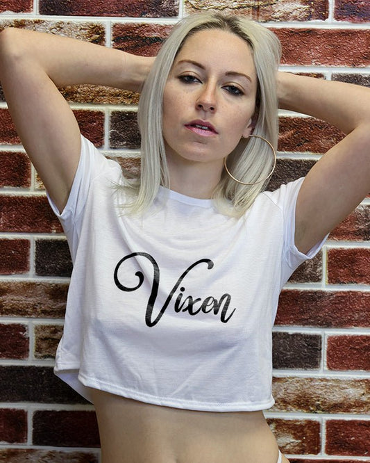 Model wearing the Wicked Boutique® Vixen Crop Top – a white crop tee with bold black script logo that reads “Vixen,” styled for confident women.