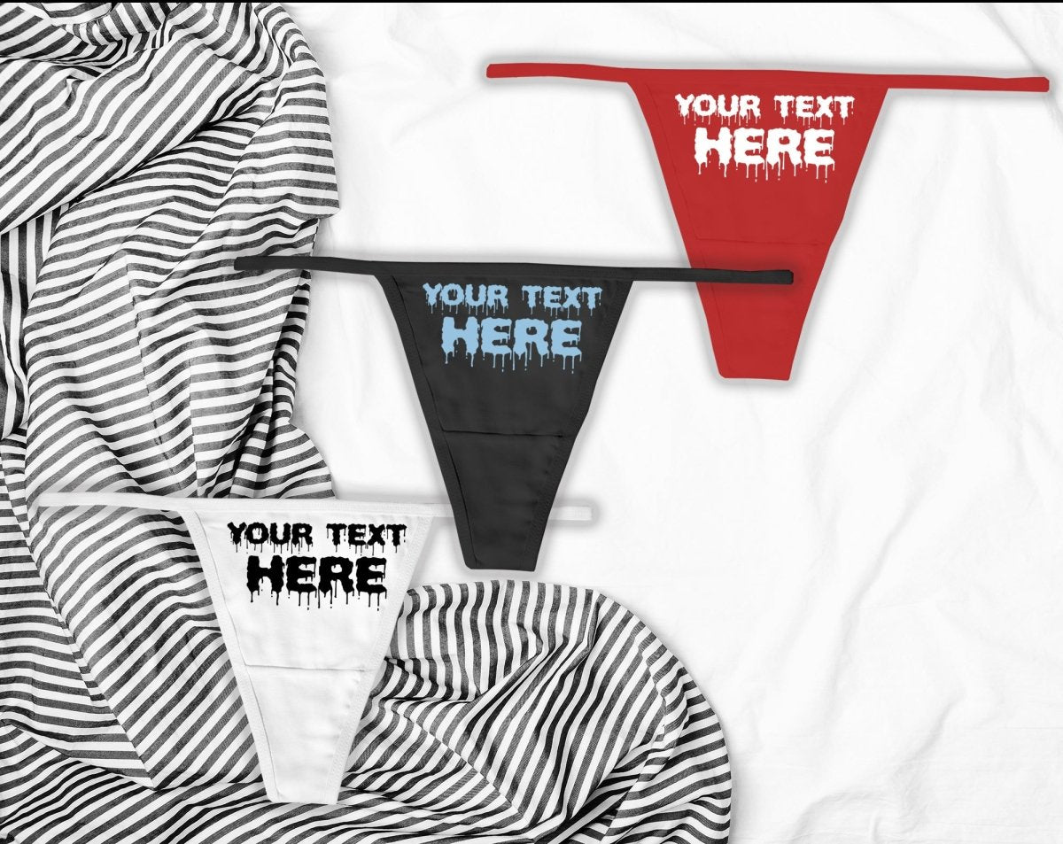 Custom wicked thong underwear with personalized text, shown in black, red, and white thongs on a striped bed background