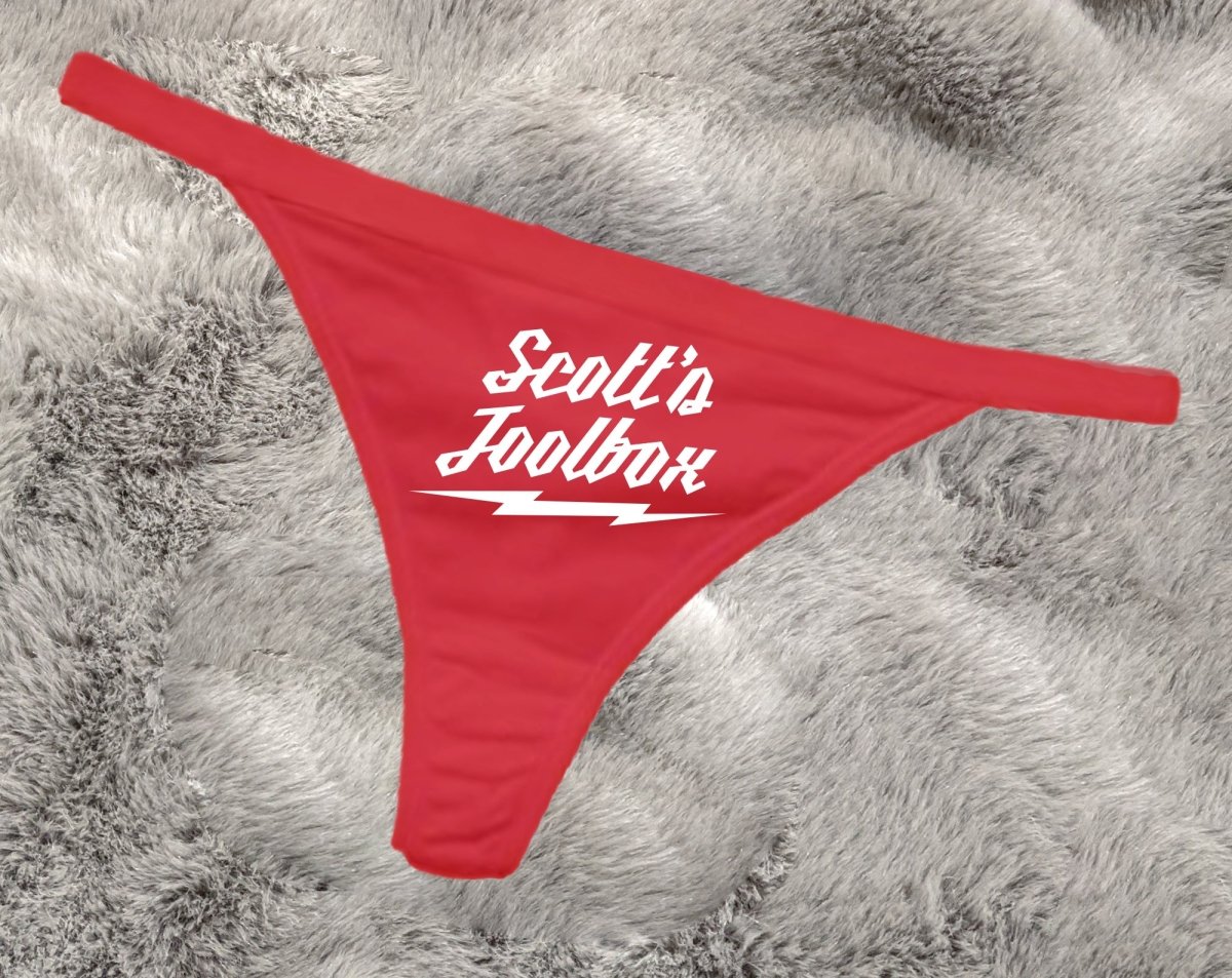Customizable red thong with 'Scott's Toolbox' text on a gray textured background